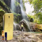 A person standing next to a waterfall with a phone.