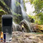 A person standing in front of a waterfall with oils.