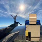 A person on top of a rock with boxes.