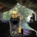 A bottle of perfume and a small container in front of a cave.