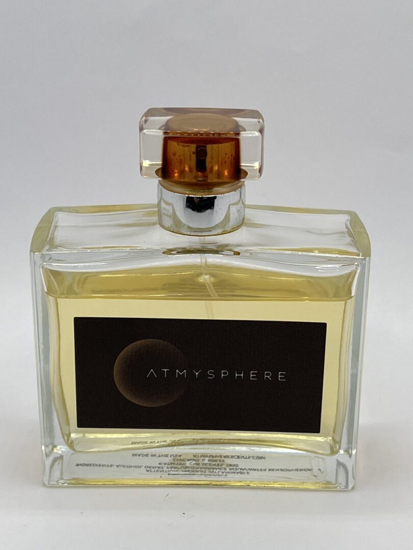 A bottle of perfume with the label " atmospheres ".