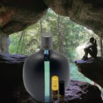 A black bottle sitting in the middle of a cave.