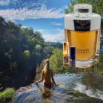 A woman in the water next to a bottle of perfume.