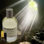 A bottle of perfume and some oils in front of a cave.