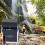 A man standing in front of a waterfall.