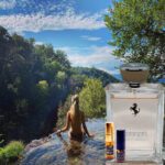 A woman in the water with a bottle of perfume.