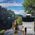 A woman in the water with bvlgari and jean by the river.