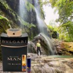 A man standing in front of a waterfall next to bvlgari.