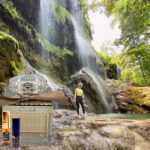 A person standing in front of a waterfall.