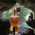 A bottle of whiskey sitting in the middle of a cave.