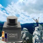 A man standing on top of a mountain with cygnus cologne.