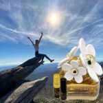 A person jumping in the air over rocks with a bottle of perfume.