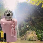 A pink bottle of perfume sitting on top of a table.