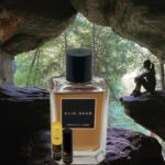 A bottle of perfume and two bottles in front of a cave.