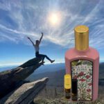 A person is jumping over the rocks with a bottle of perfume and a roller ball.