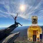 A person on top of a rock with a bottle.