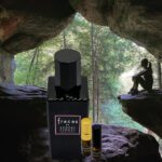 A bottle of perfume sitting in the middle of a cave.