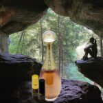 A bottle of perfume sitting in the middle of a cave.