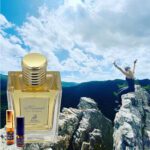 A person jumping in the air over rocks with an open bottle of perfume.