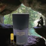 A bottle of perfume sitting in the middle of a cave.