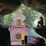 A bottle of perfume sitting in the middle of a cave.