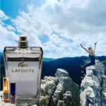 A person jumping in the air over rocks with lacoste