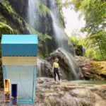 A person standing in front of a waterfall.