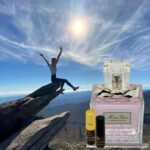 A person is jumping off the cliff with an open bottle of perfume.