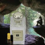 A bottle of perfume sitting in the middle of a cave.