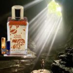 A bottle of perfume and a man standing in front of a cave.