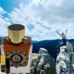 A bottle of perfume and two bottles of oils on top of a mountain.