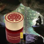 A jar of aroma fragrance sitting in front of a cave.