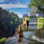 A woman standing in the water next to trees.