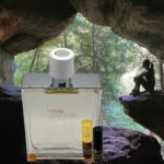 A bottle of perfume sitting in the middle of a cave.