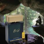 A bottle of perfume and a box of fragrance in front of a cave.