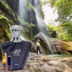 A person standing in front of a waterfall with a bottle.