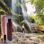 A person standing in front of a waterfall