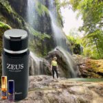 A person standing in front of a waterfall with zeus products.